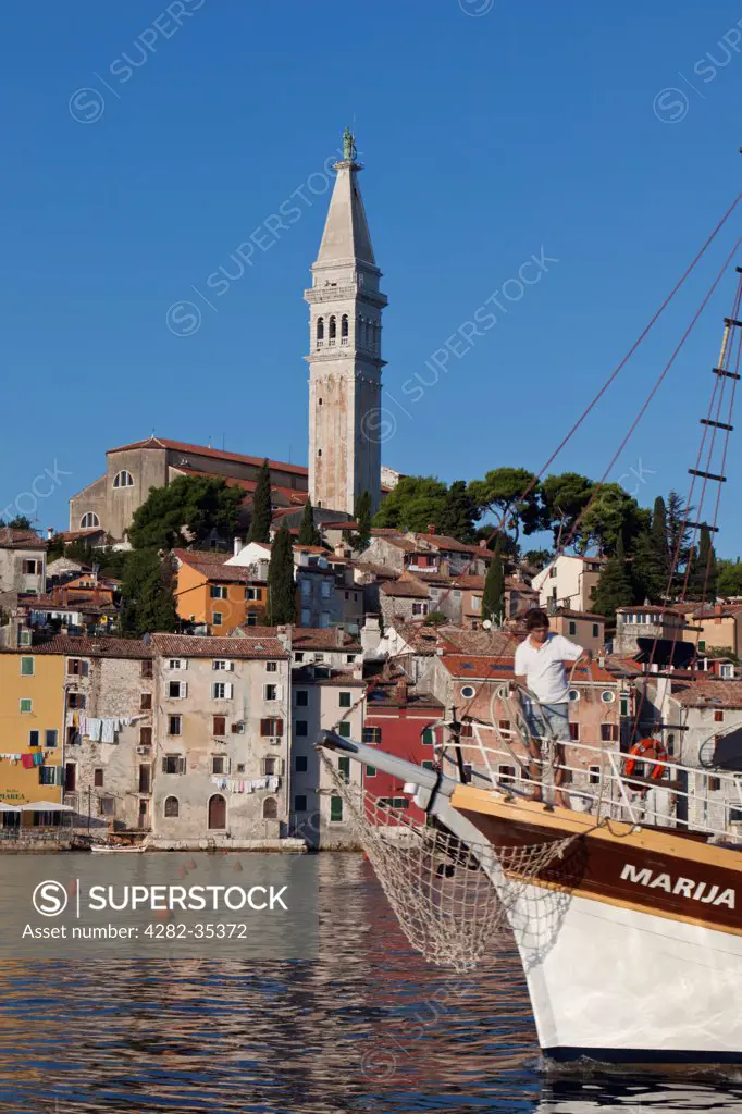 Croatia, Istria, Rovinj. A sailboat enters Old Town waterfront at Rovinj.