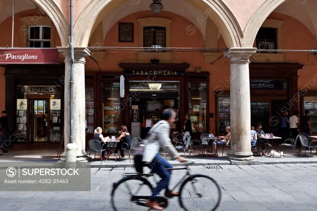 Italy, Emilia-Romagna, Bologna. A cyclist passes a tabaccheria in the historical centre of Bologna.