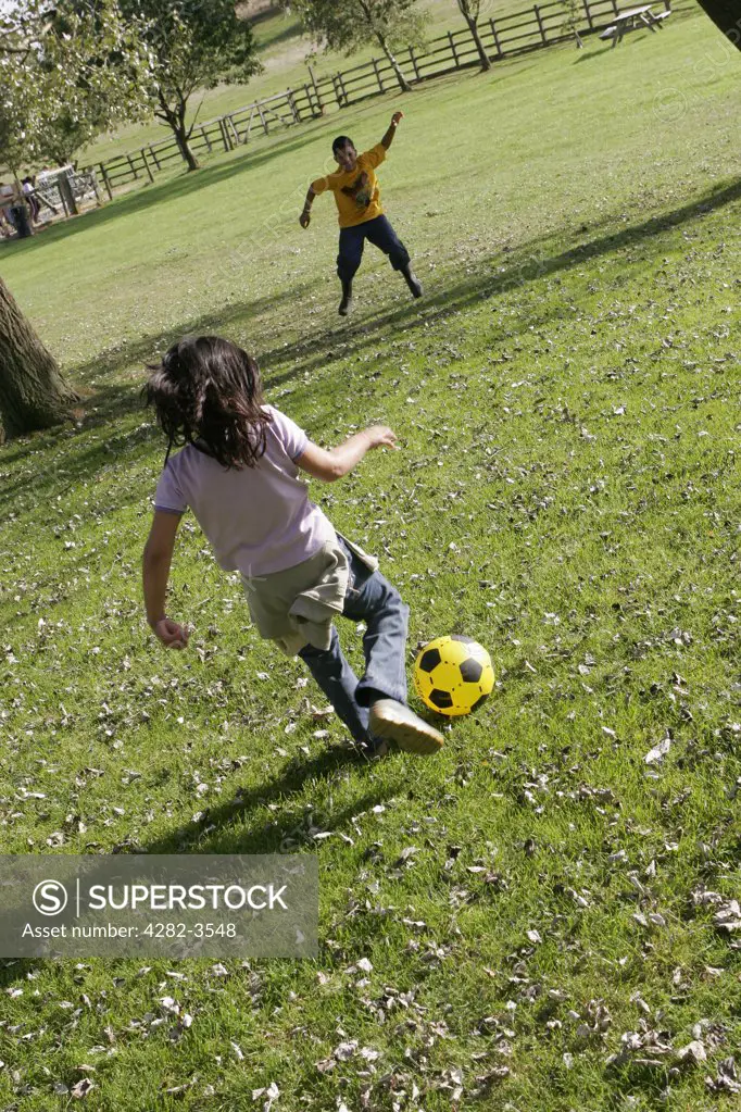 England, Worcestershire, Waseley Hills. Children playing football in Waseley Hills Country Park. It is 150 acres of rolling open hills with old hedgerows, pastures and small pockets of woodland with panoramic views.