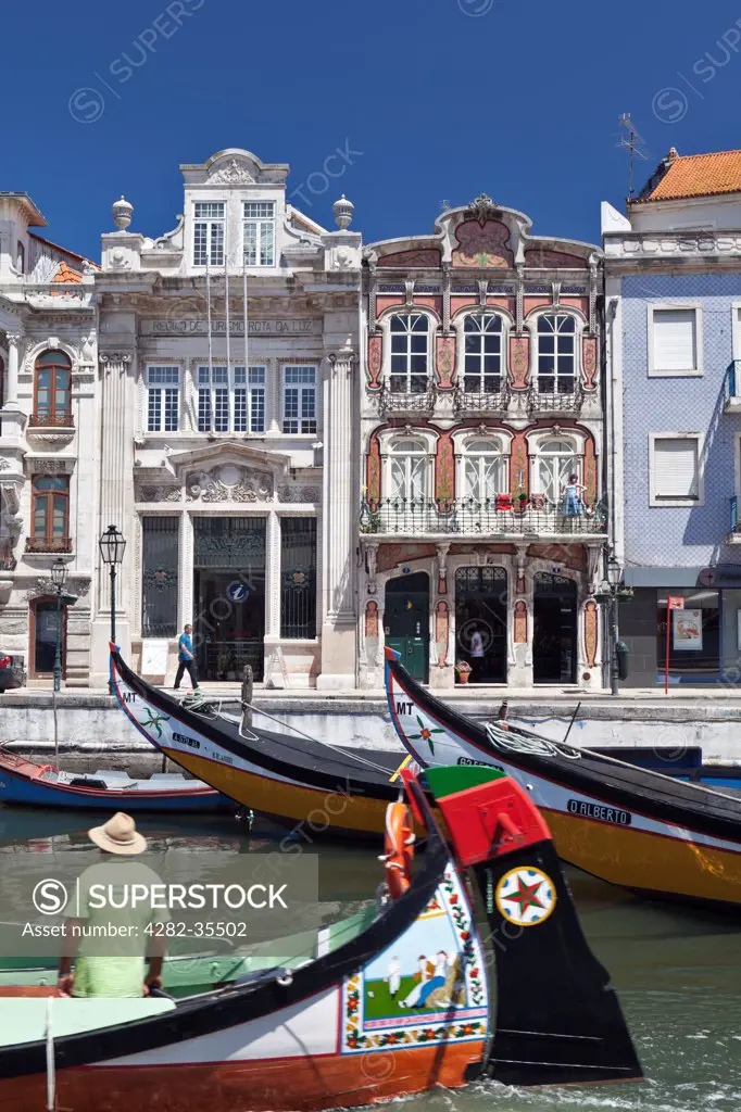 Portugal, Beira Litoral, Aveiro. Art Nouveau buildings and the prows of traditional moliceiros boats moored on the canal at Aveiro.