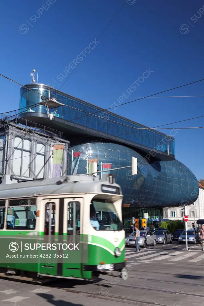 Austria, Styria, Graz. A traditional tram passes the Kunsthaus Graz art house.