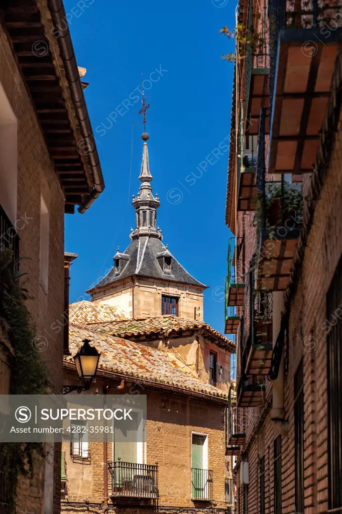 Spain, Castilla La Mancha, Toledo. The steeple of a church seen from a side street.