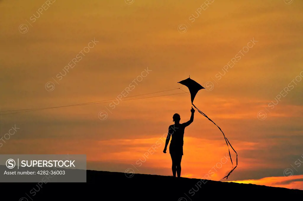 USA, North Carolina, Nags Head. Silhouette of a child flying a kite.