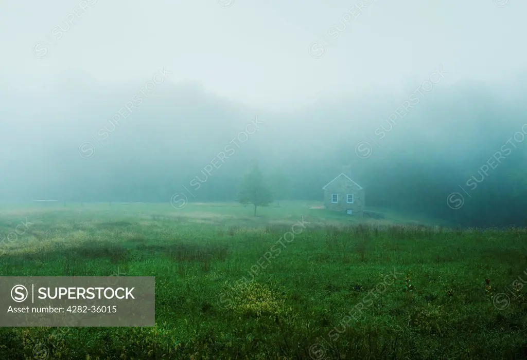 USA, Delaware, Ashland. A quaint stone cottage on a misty morning.