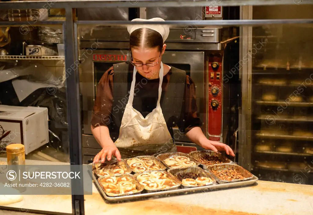 USA, Pennsylvania, Philadelphia. An Amish woman making pastries at Reading Terminal Market.