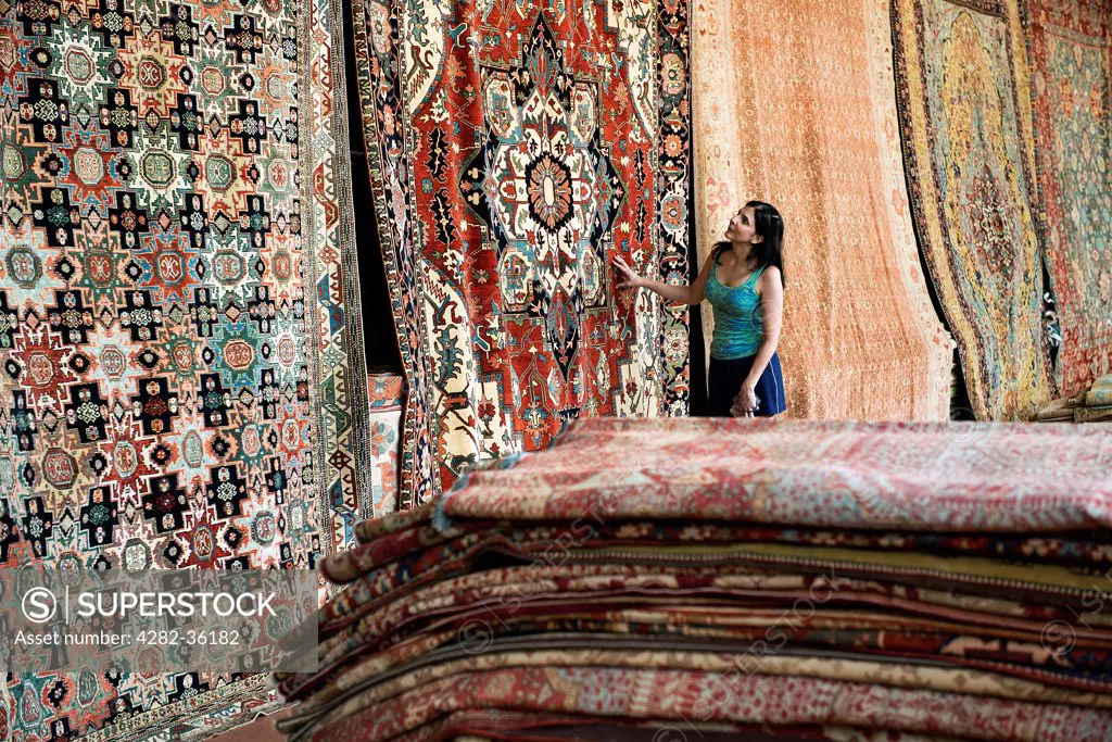 USA, Pennsylvania, Philadelphia. A woman shopping for an oriental rug.
