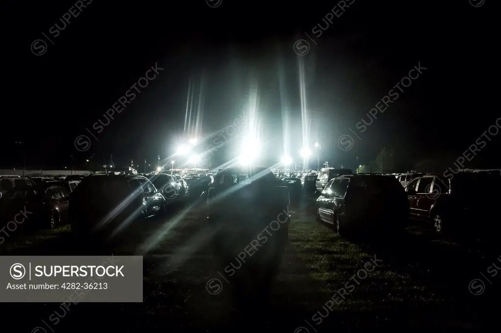 USA, New Jersey, Cowtown. Cars parked in a grass field for an evening rodeo event in Cowtown.