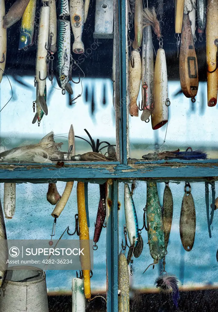 USA, Massachusetts, Marthas Vineyard. Hooks and lures in a fishing shack window in Menemsha.