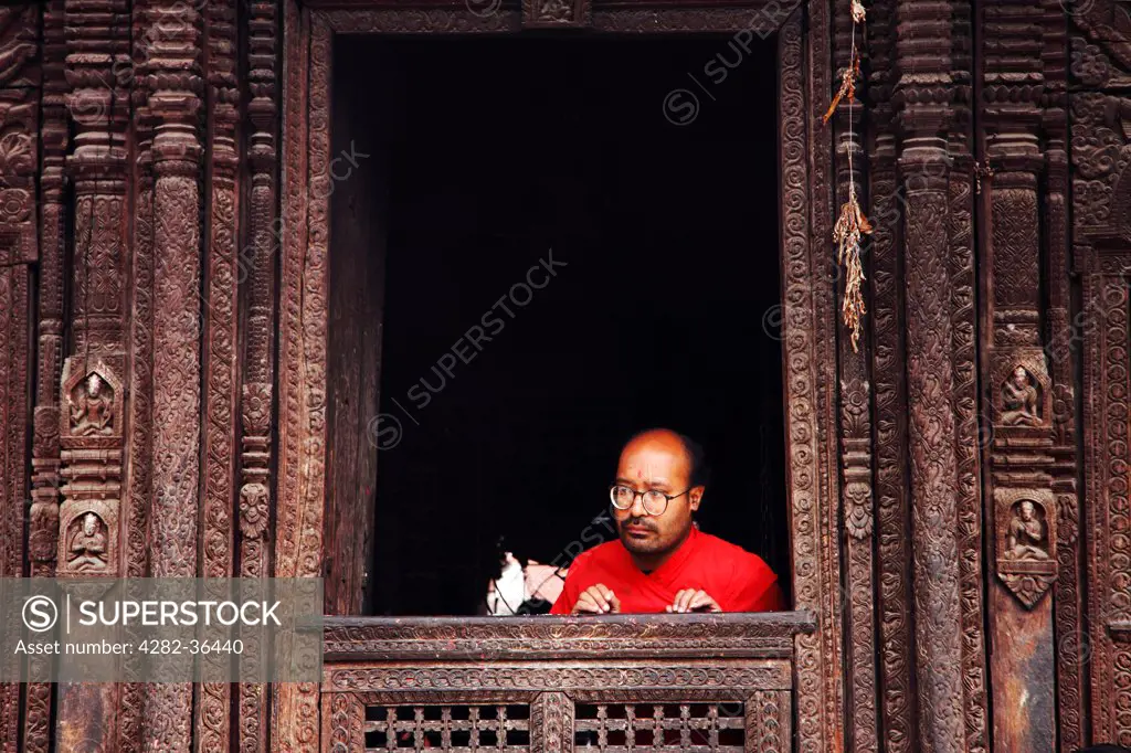 Nepal, Kathmandu, Patan. A man inside the Kumbeshwar temple in Patan.