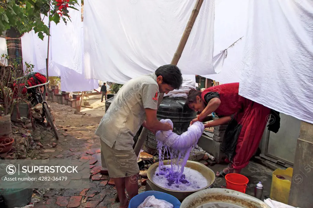 Nepal, Kathmandu, Kathmandu Metropolitan City. Workers wringing some linen.