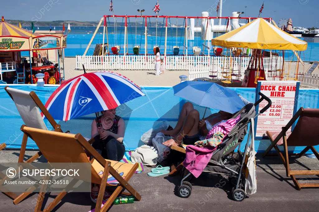 England, Dorset, Weymouth. Girls with umbrellas.