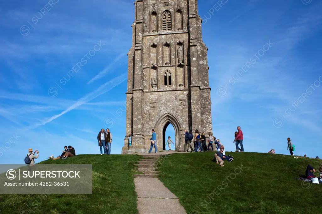 England, Somerset, Glastonbury. St Michael's church and tourists on Glastonbury Tor hill.