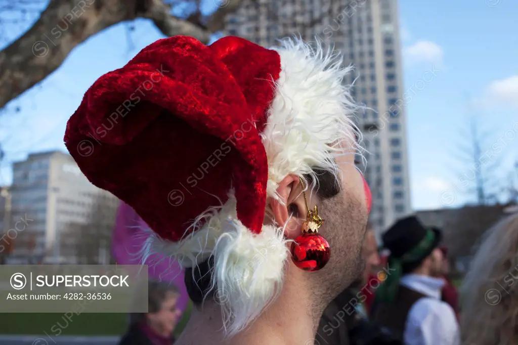 England, London, South Bank. Man wearing a santa hat.