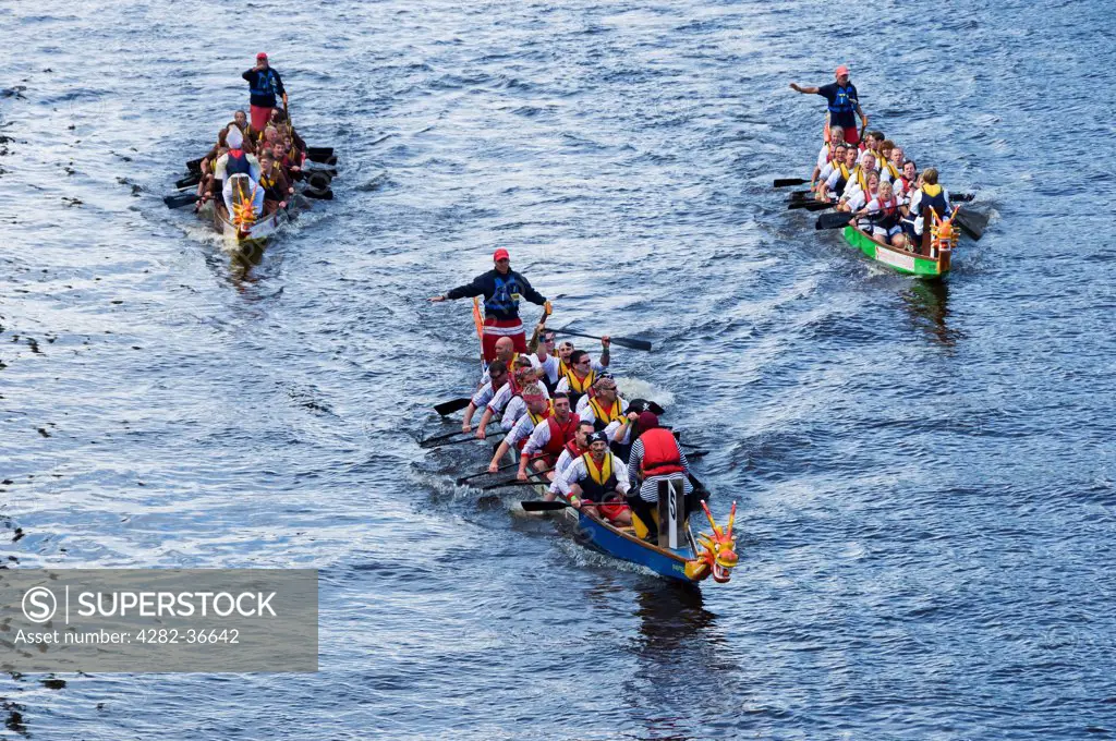 England, North Yorkshire, York. Boats crossing the finishing line at the Dragon Boat Challenge on the River Ouse.