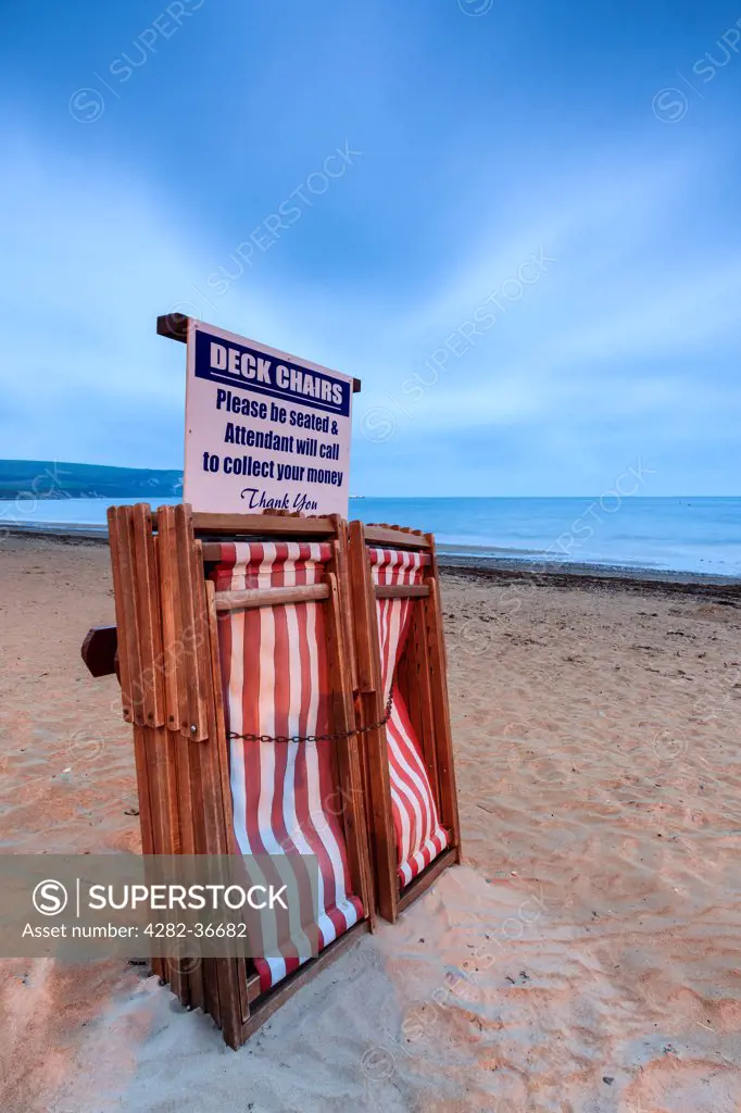 England, Dorset, Swanage. Deckchairs on the beach at Swanage on a cloudy morning.