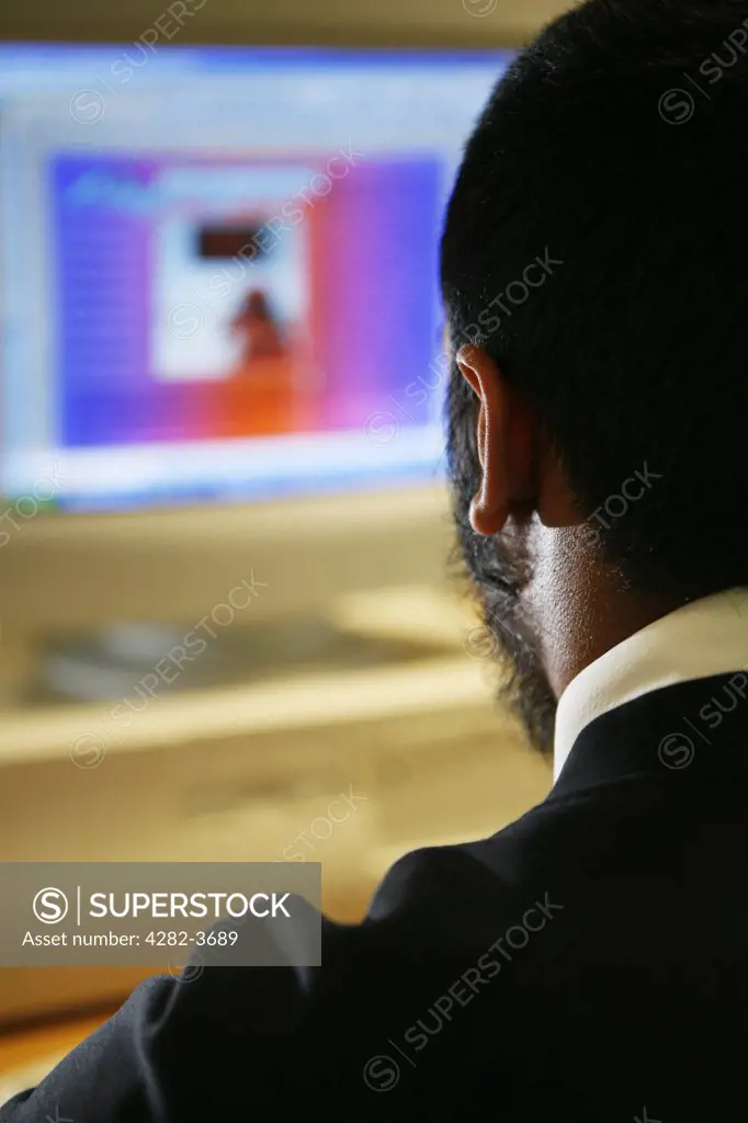 England, West Midlands, Birmingham. An Asian student working on a computer.