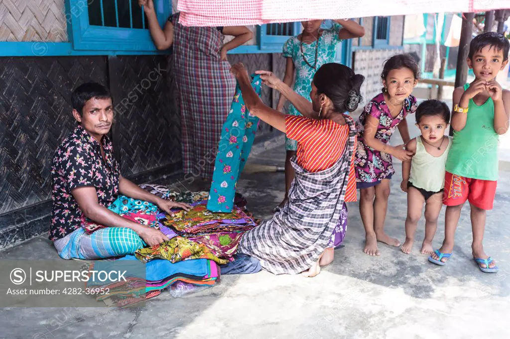 Bangladesh, Sylhet, Srimangal. A salesman selling cloths to the local Khasi tribal women.