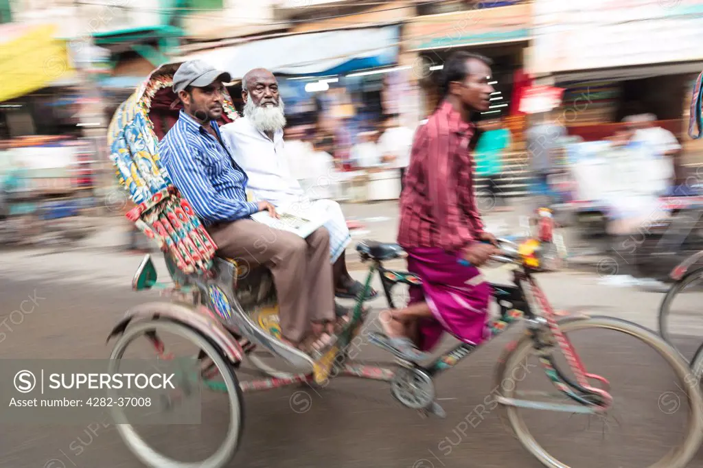 Bangladesh, Dhaka, Dhaka. Cycle rickshaw driver making his way through the traffic.