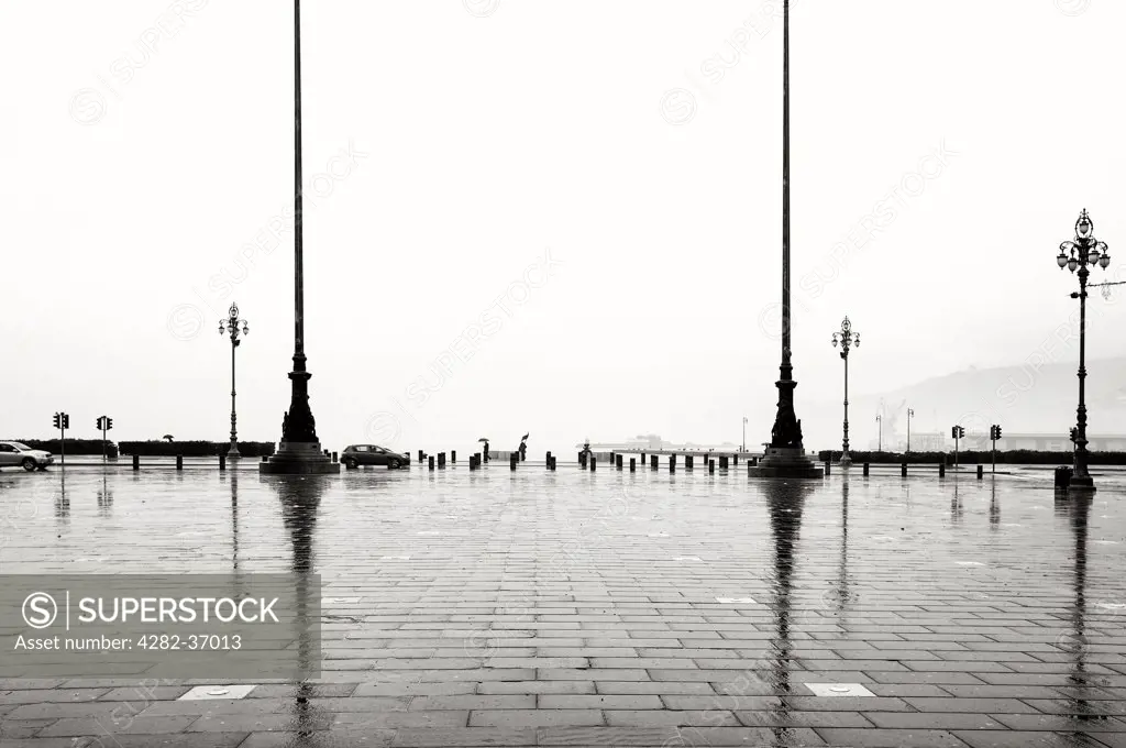Italy, Trieste, Port Of Trieste. Rainy urban scene with people with umbrellas in the back.