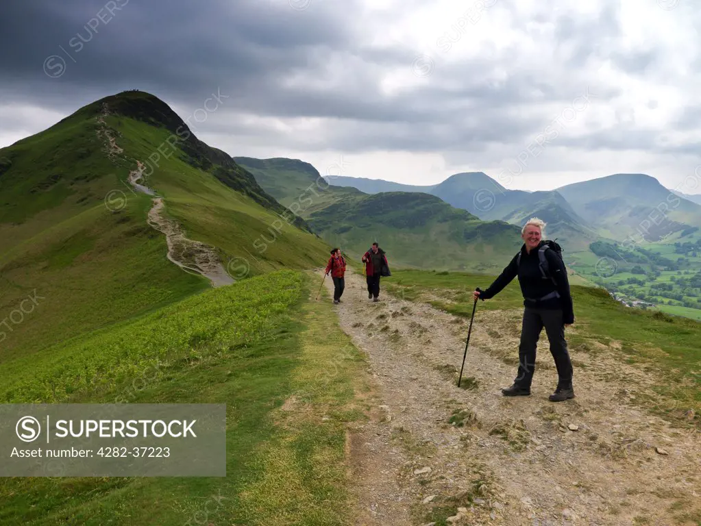 England, Cumbria, Keswick. Three walkers on the slopes of Catbells in the English Lake District.