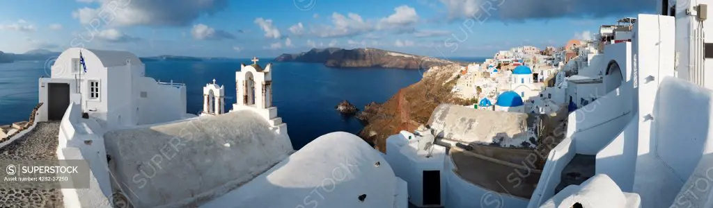 Greece, Santorini, Oia. Houses and churches cling to the sides of the cliff in the village of Oia.