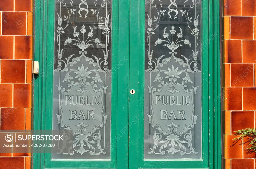 England, London, Fitzrovia. A public bar sign on glass doors at a Fitzrovia pub.