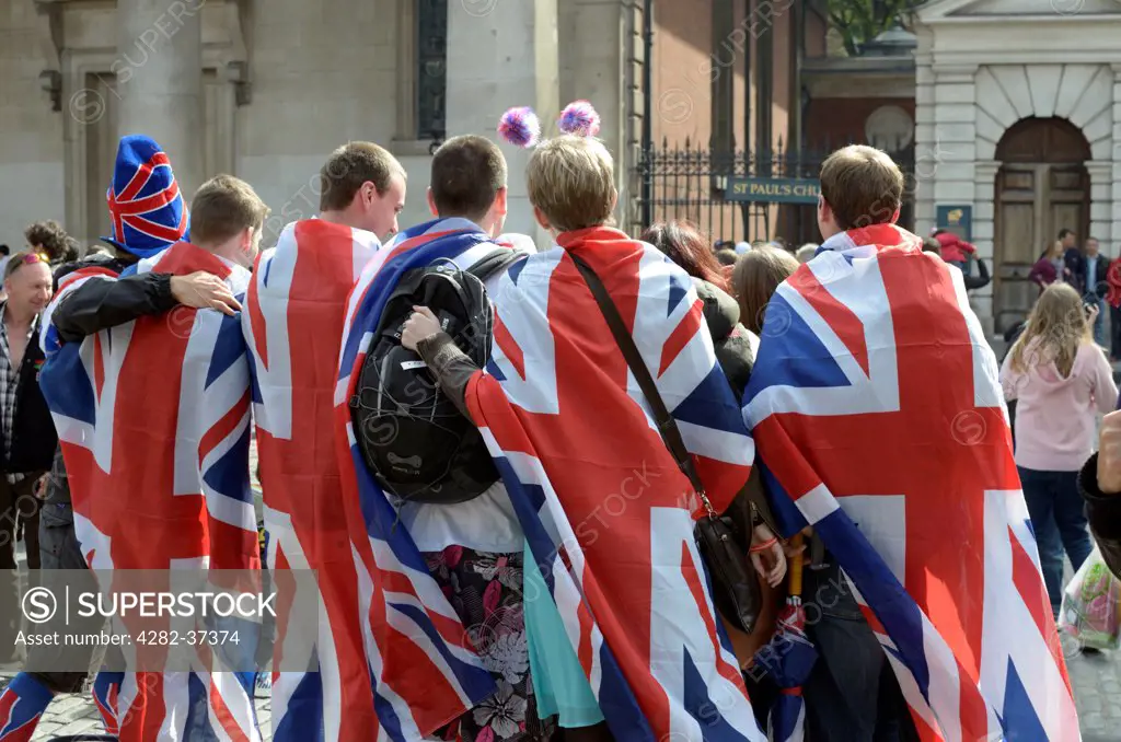 England, London, Covent Garden. A group of revellers draped in Union Jack flags.