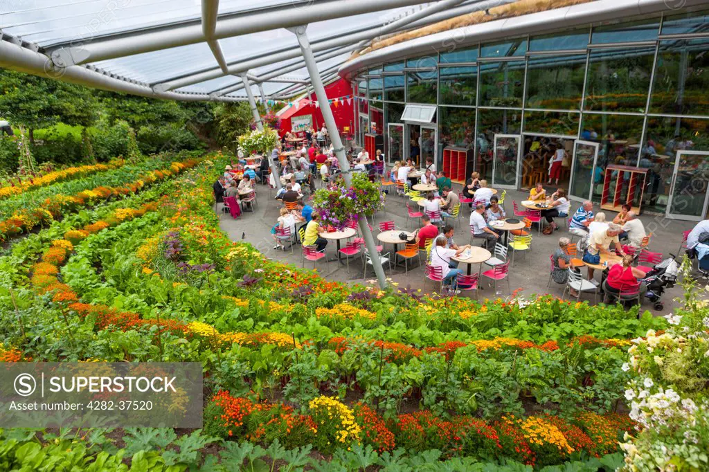 England, Cornwall, St Blazey. People sitting outside the restaurant in the Eden Project.