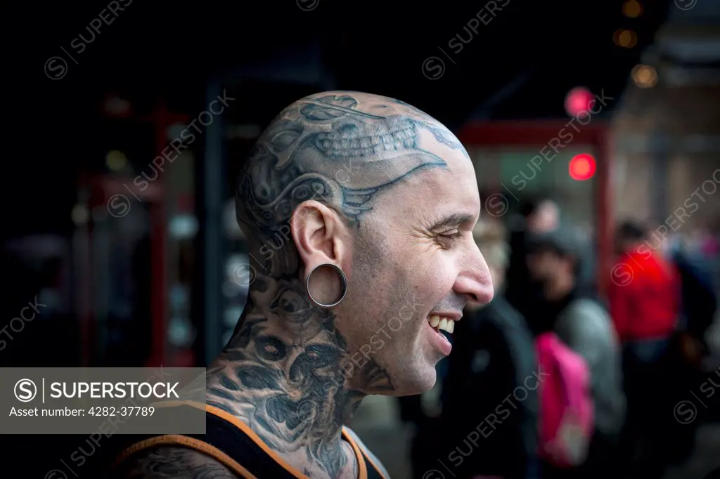 England, London, Tobacco Dock. Profile of tattooed male with shaved head at the London International Tattoo Convention.