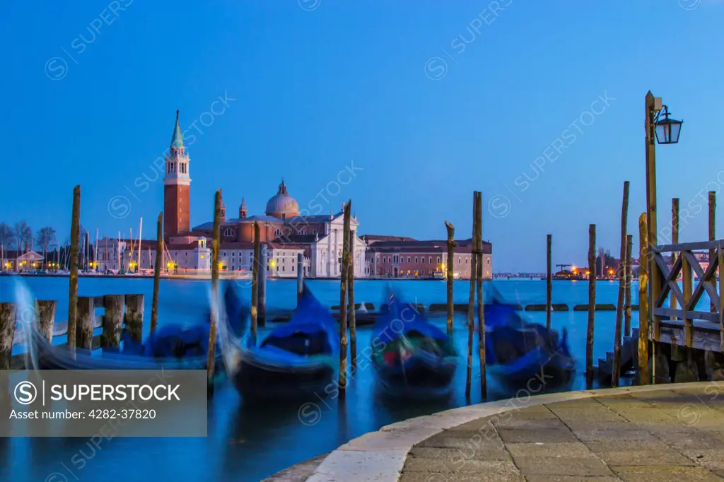 Italy, Veneto, Venice. A view of floating gondolas towards San Giorgio Maggiore church.