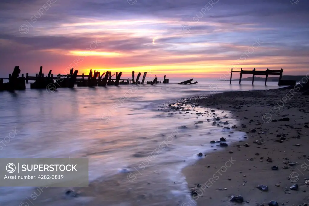 England, Norfolk, Happisburgh. The wooden sea defences and rocks which have been placed on Happisburgh beach to help protect against coastal erosion.