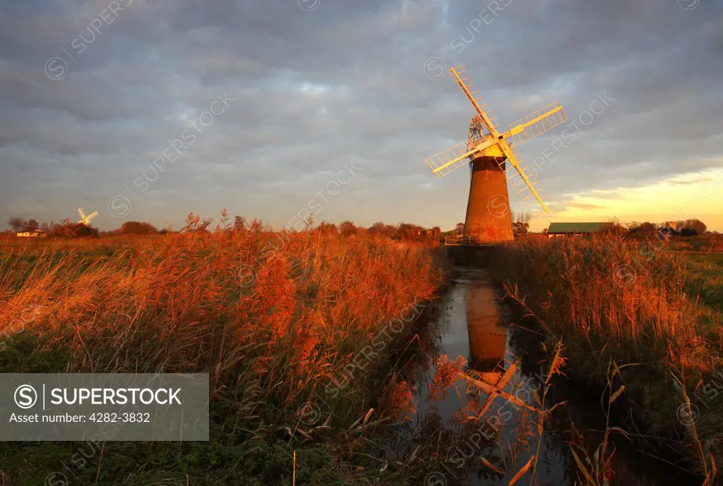 England, Norfolk, St. Benets Windmill. St. Benets windpump with Thurne windpump in the distance at last light on the Norfolk Broads.