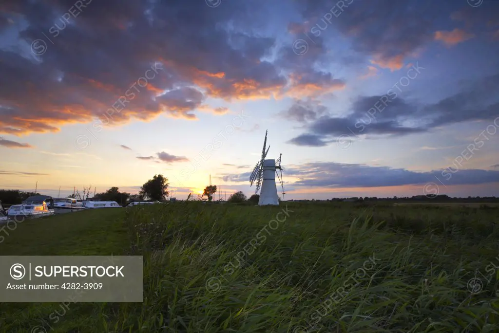 England, Norfolk, Thurne. Thurne Dyke & windmill at sunset on the Norfolk Broads.