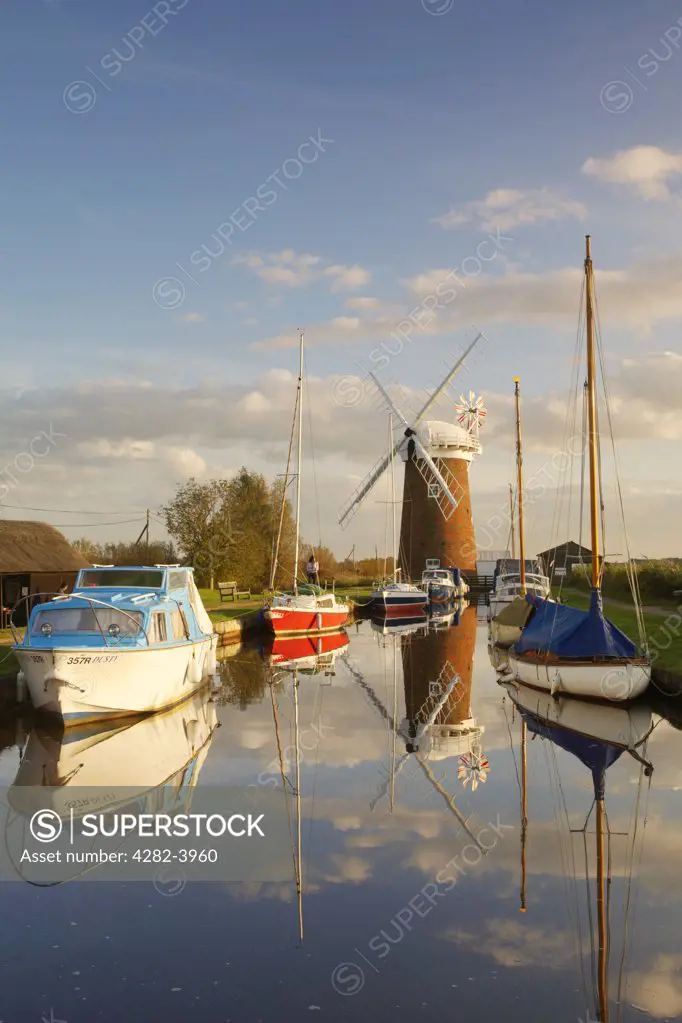 England, Norfolk, Brancaster Staithe. Horsey Windmill and boats moored at Brancaster Staithe in Norfolk.
