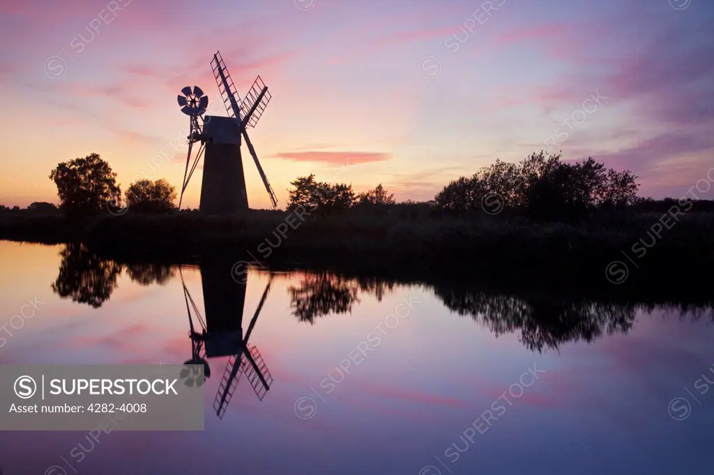 England, Norfolk, Near How Hill. Turf Fen drainage mill at sunset on the River Ant in the Norfolk Broads.
