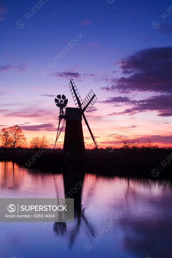 England, Norfolk, Near How Hill. Turf Fen drainage mill at sunset on the River Ant in the Norfolk Broads.