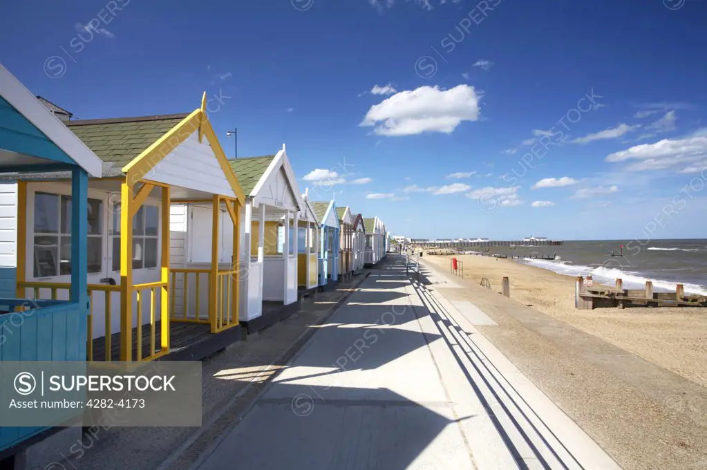 England, Suffolk, Southwold. A row of colourful beach huts on the seafront at Southwold on a summers day on the Suffolk Coast.