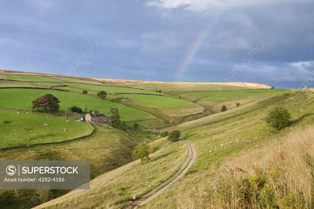 England, Derbyshire, Peak District National Park. A rainbow over countryside in the Peak District National Park.