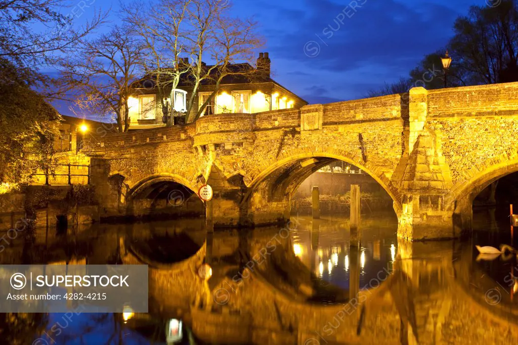 England, Norfolk, Norwich. The medieval Bishop Bridge over the River Wensum at night. The bridge was built in 1340 and is one of the oldest bridges still in use in England.