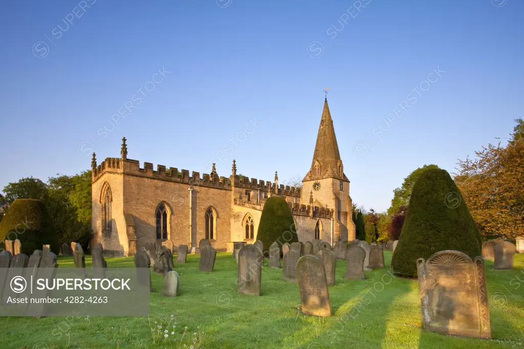 England, Derbyshire, Baslow. First light over the parish church of St Anne in Baslow. The clock face has VICTORIA 1897 in the place of numbers in commemoration of Queen Victoria's diamond jubilee.