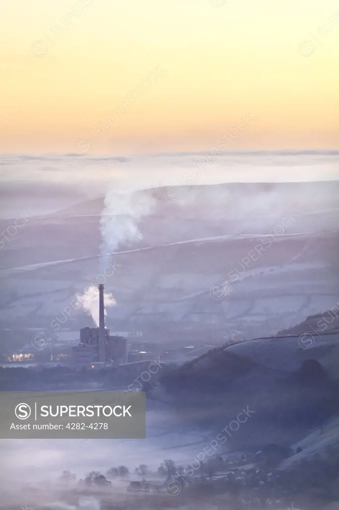 England, Derbyshire, Hope Valley. Hope Valley Cement Works shrouded in mist at sunrise in the Peak District National Park.