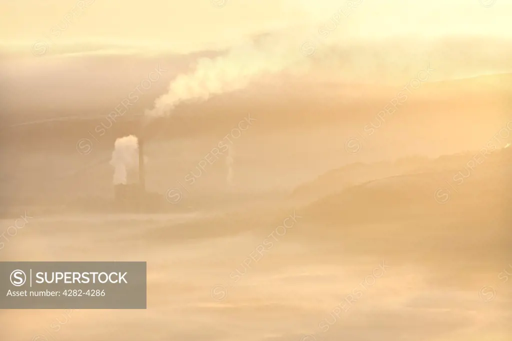 England, Derbyshire, Hope Valley. Hope Valley Cement Works shrouded in mist at sunrise in the Peak District National Park.
