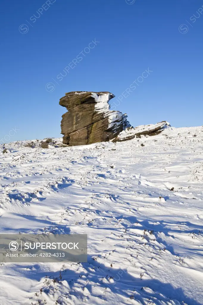 England, Derbyshire, Peak District National Park. Snow on and surrounding Mother Cap, a large gritstone rock formation in the Peak District National Park.