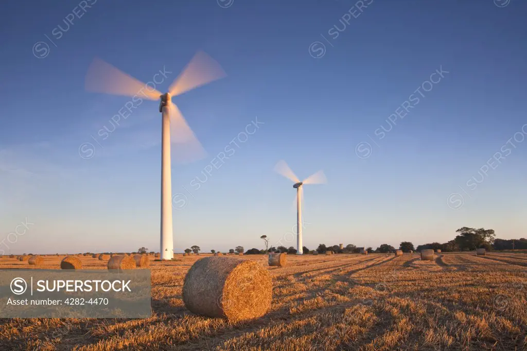 England, Norfolk, Winterton-on-Sea. Hay Bales and wind turbines on Blood Hill at Winterton Windfarm.