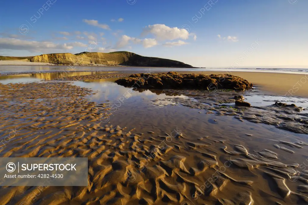 England, Glamorgan, Southerndown. A view to the reef formed by Honeycomb Worm at Dunraven Bay. The ruins of Dunraven Castle (actually a 19th century mansion) stand upon the headland at Dunraven Bay.