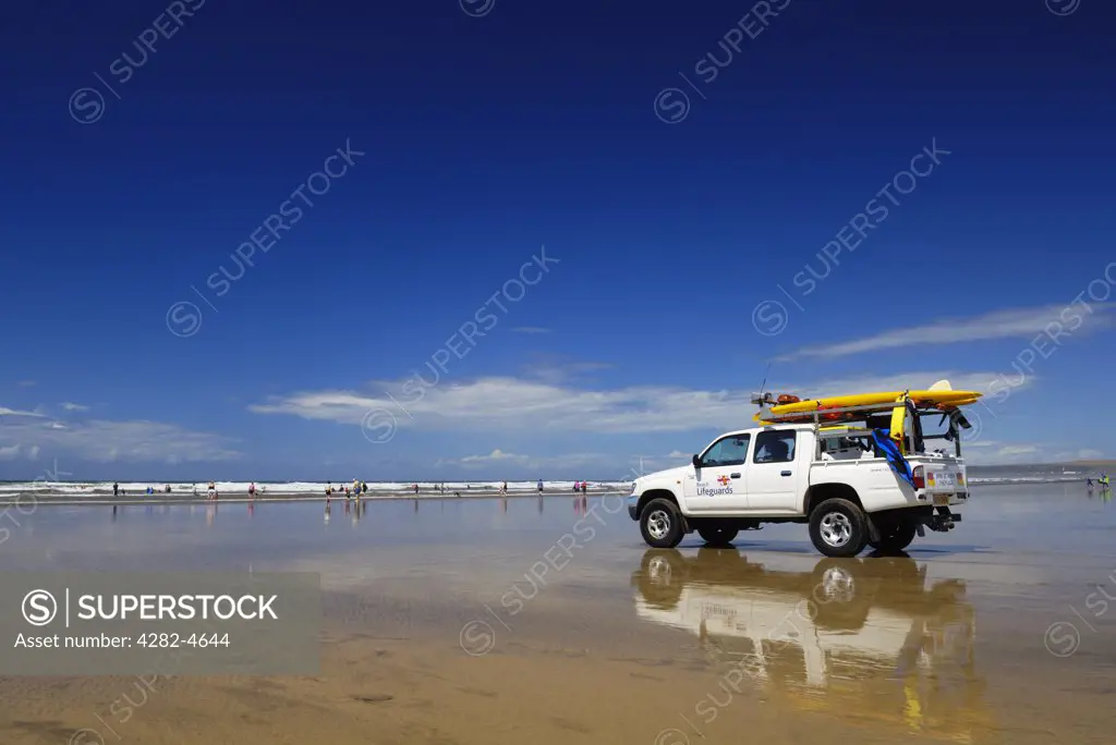 England, Devon, Westward Ho!. An RNLI lifeguard vehicle looks out to sea at swimmers at Westward Ho! beach. At Westward Ho! there are two miles of sandy beach known as the Golden Bay.