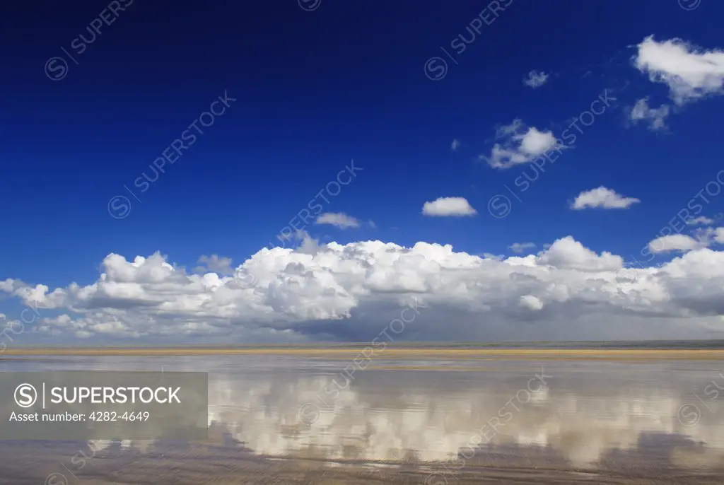 England, Devon, Westward Ho!. A cloud formation and blue sky reflected in shallow water on the beach at Westward Ho! At Westward Ho! there are two miles of sandy beach known as the Golden Bay.