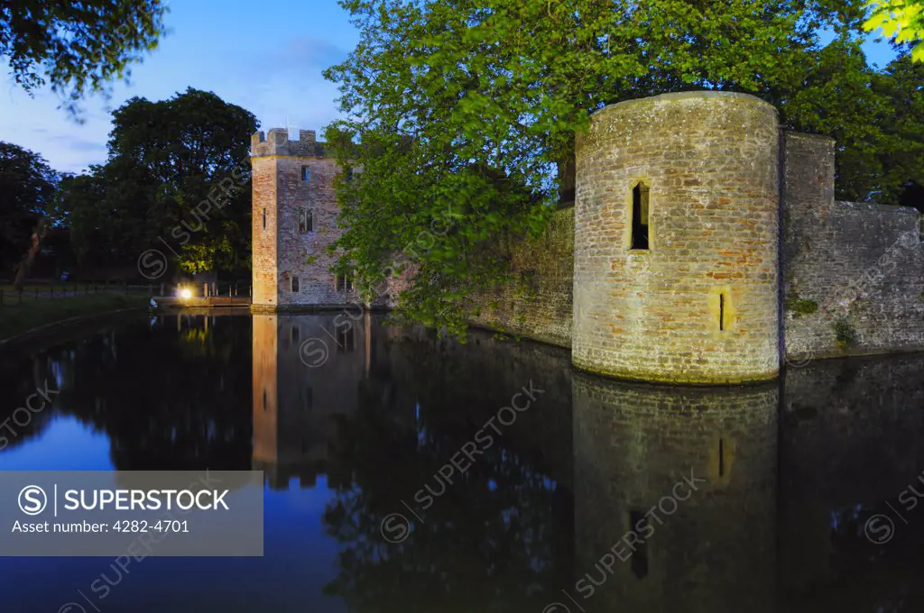 England, Somerset, Wells. The floodlit moat and outer wall around the Bishop's Palace and gardens.
