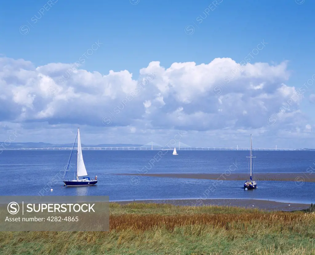 England, Somerset, Portishead. Sailing boats on the mouth of the River Severn with the Severn Crossing bridges in the distance.