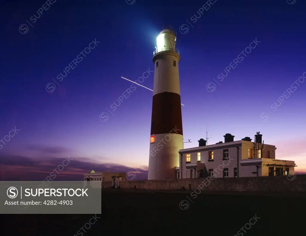 England, Dorset, Portland Bill. An illuminated Portland Bill lighthouse at dusk on the Dorset Jurassic Coast.